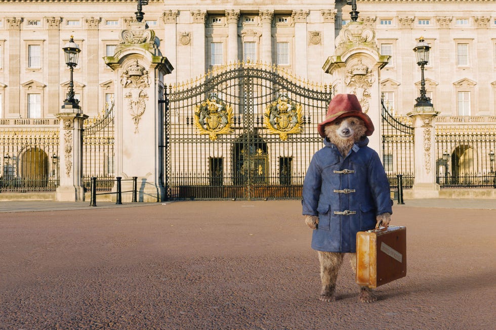 a character stands in front of a grand building with ornate gates and classical architecture