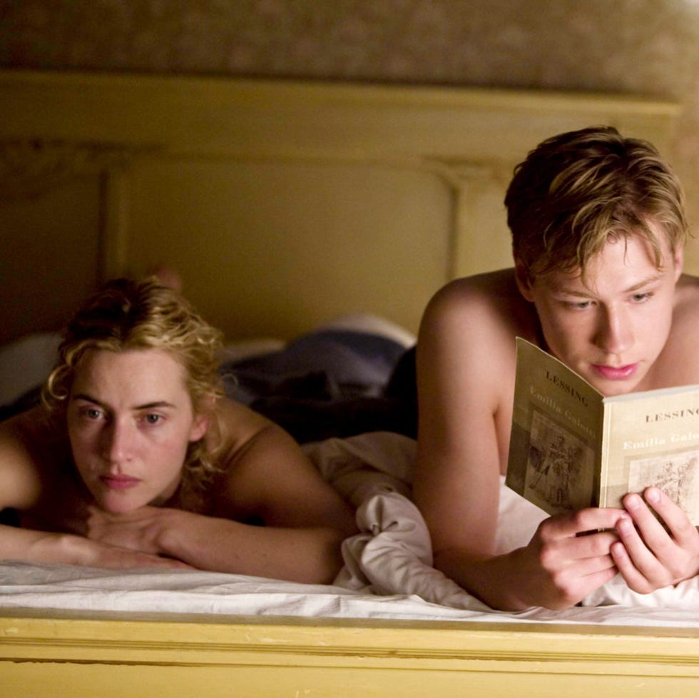two individuals in bed one reading a book two individuals in bed one reading a book