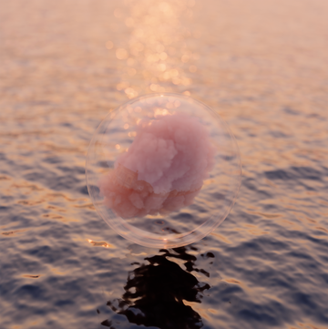 bubble floating over water with pink cloud inside bubble floating over water with pink cloud inside
