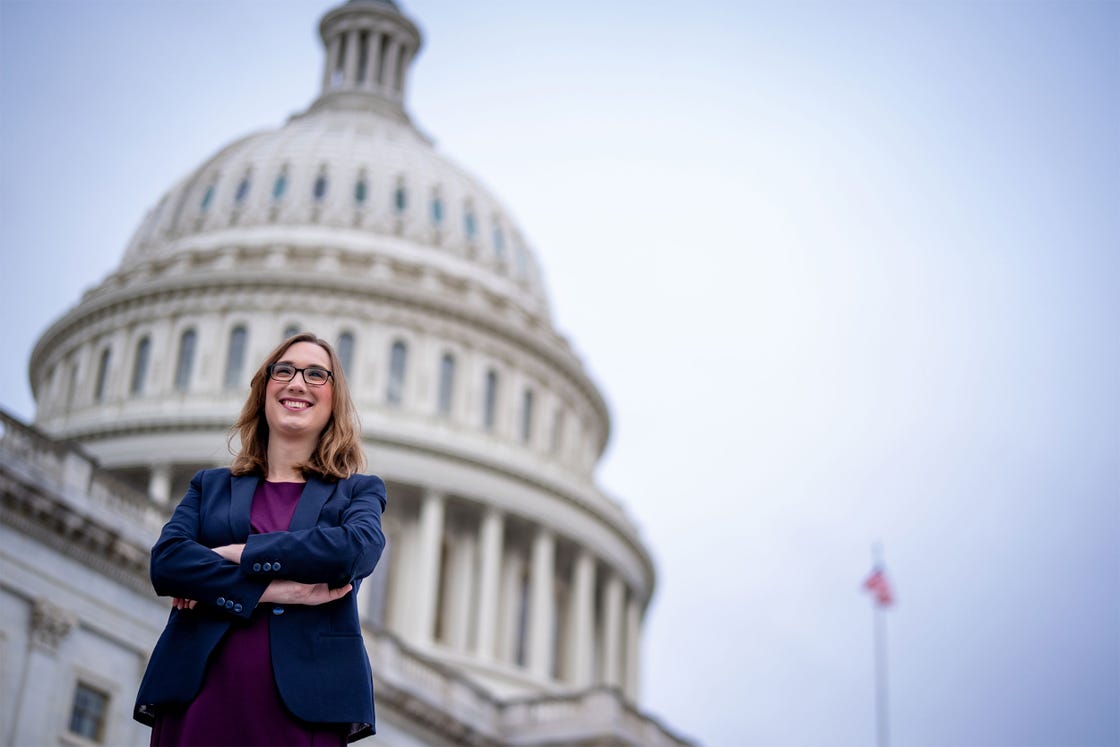 individual standing confidently in front of a large government building
