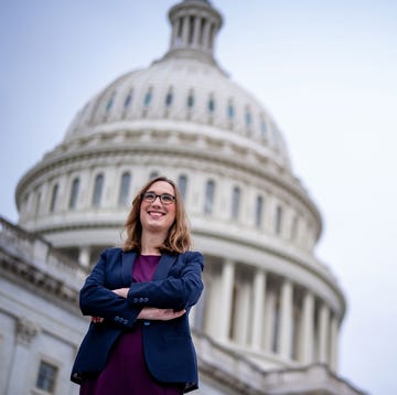 individual standing confidently in front of a large government building individual standing confidently in front of a large government building