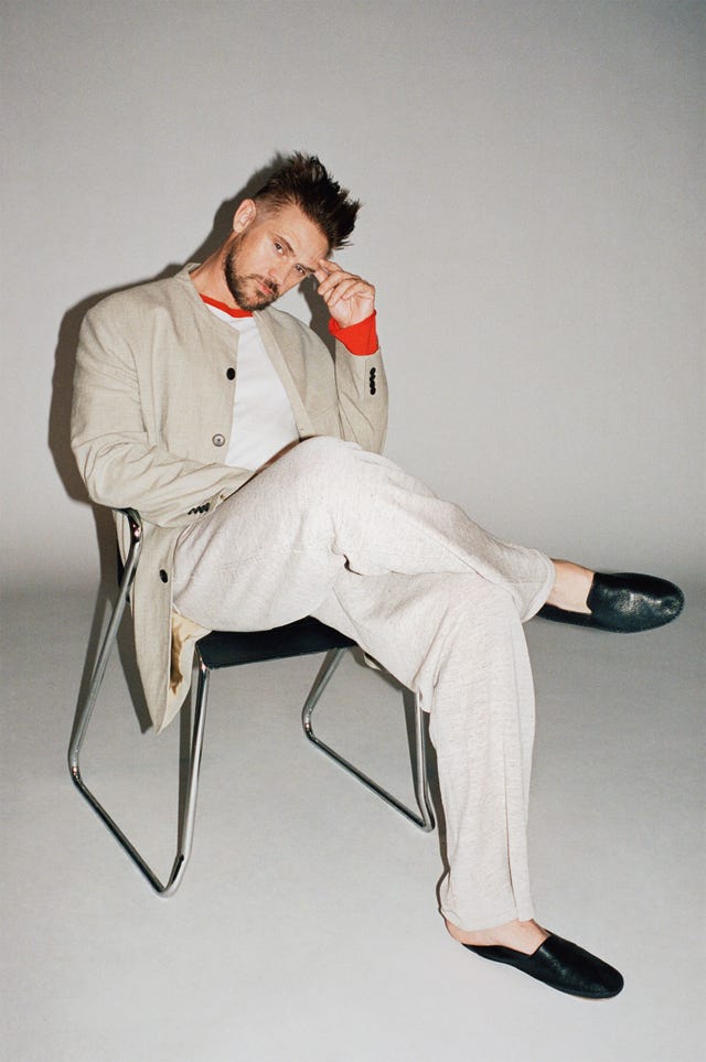 individual seated on a chair portraying a relaxed yet stylish demeanor