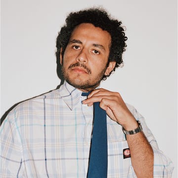 individual adjusting a tie while wearing a checkered shirt individual adjusting a tie while wearing a checkered shirt
