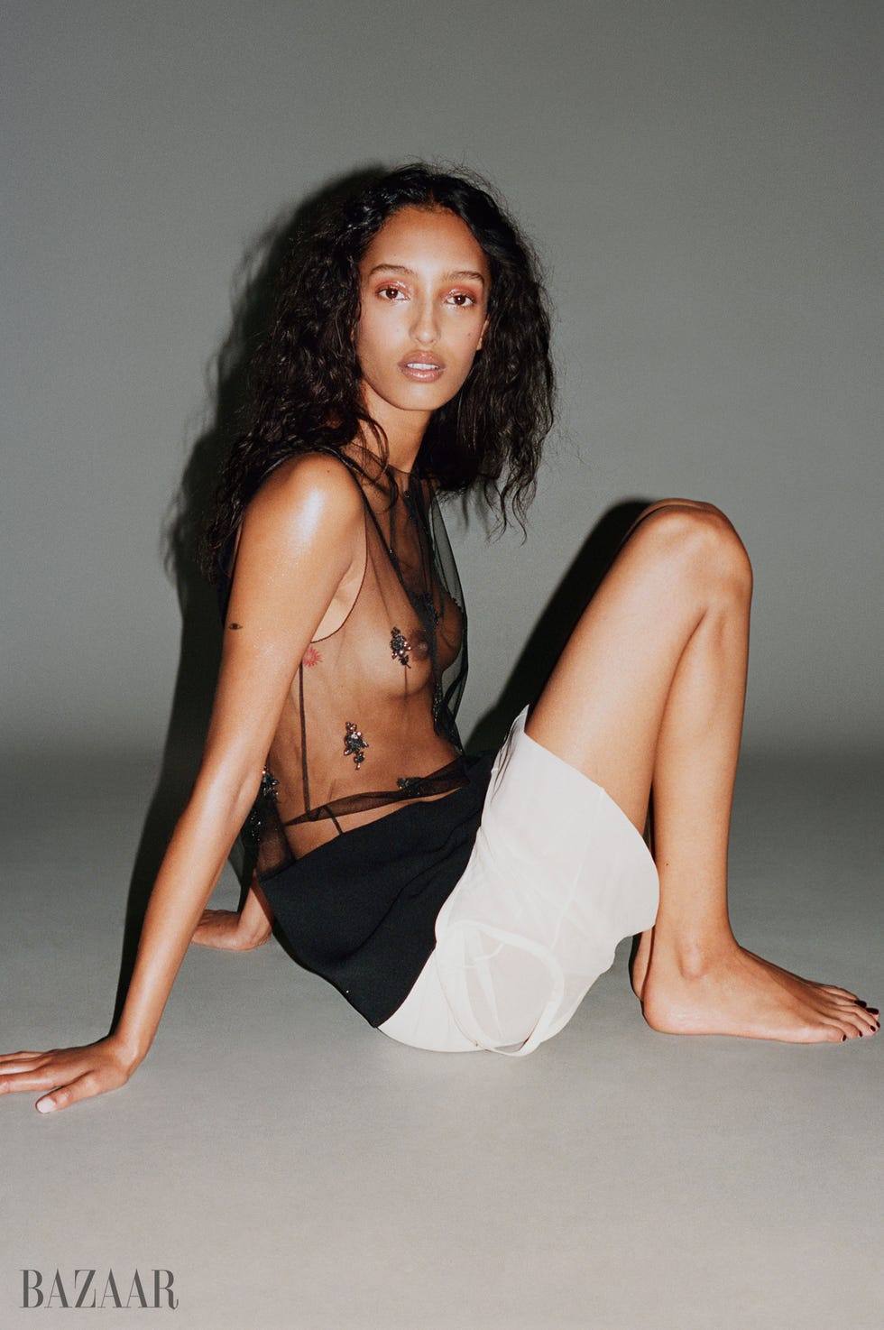 an individual seated in a fashionable outfit with a focus on contemporary styling
