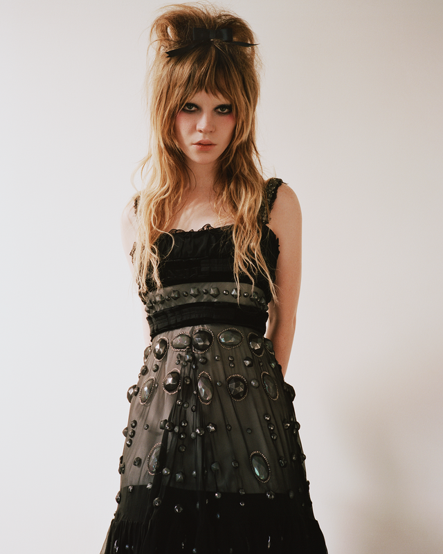 a figure wearing an intricate black dress with embellishments