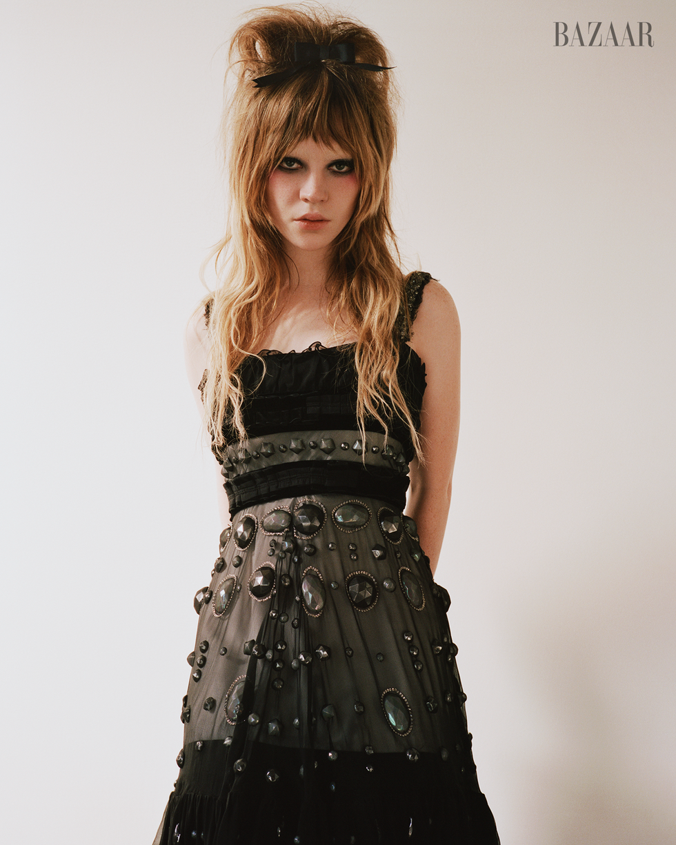 model wearing a black embellished dress against a neutral background