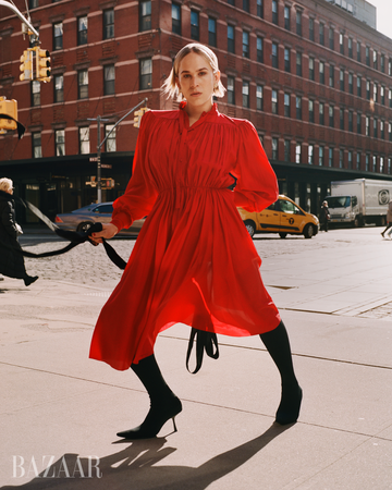 woman in a vivid red dress walks on a city street