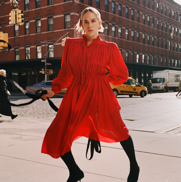 woman in a vivid red dress walks on a city street woman in a vivid red dress walks on a city street