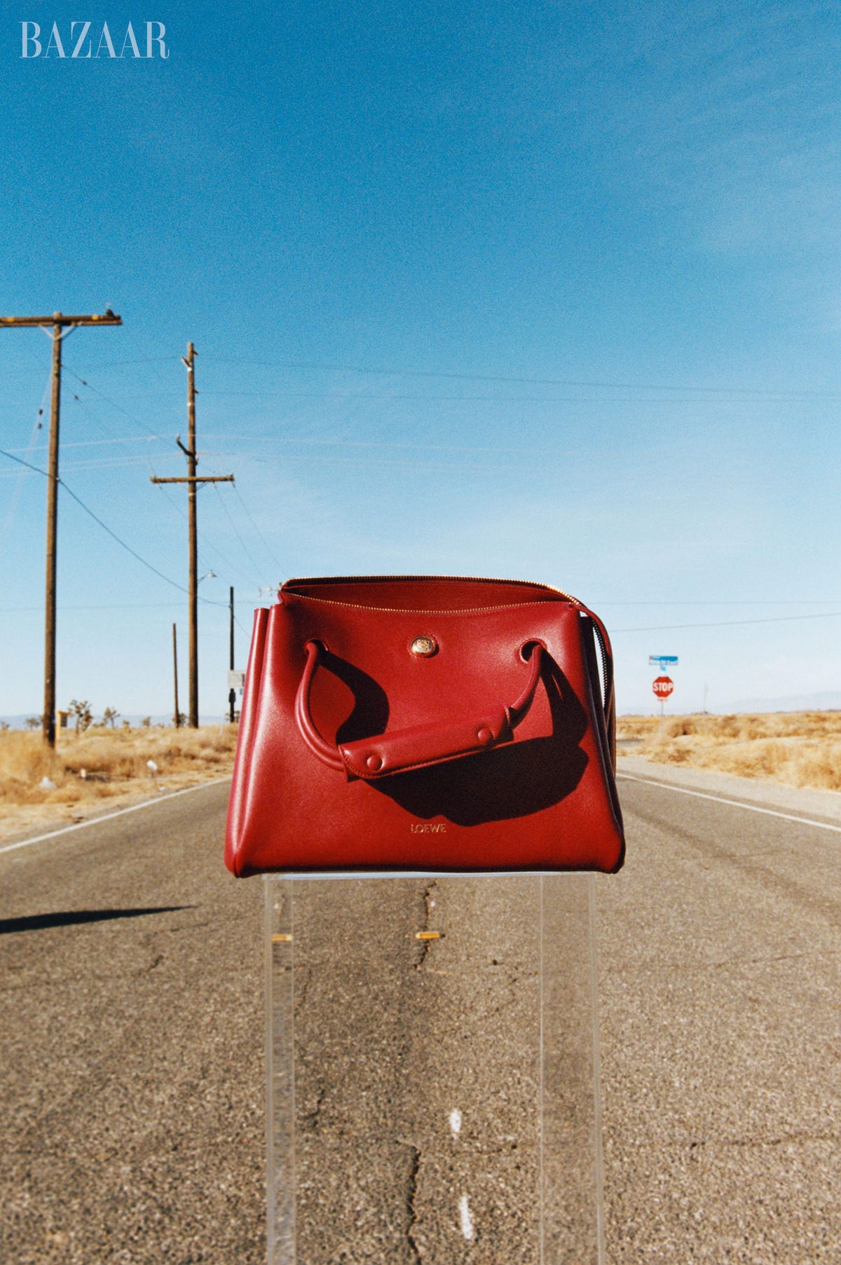 red loewe purse sitting on an open road in the desert