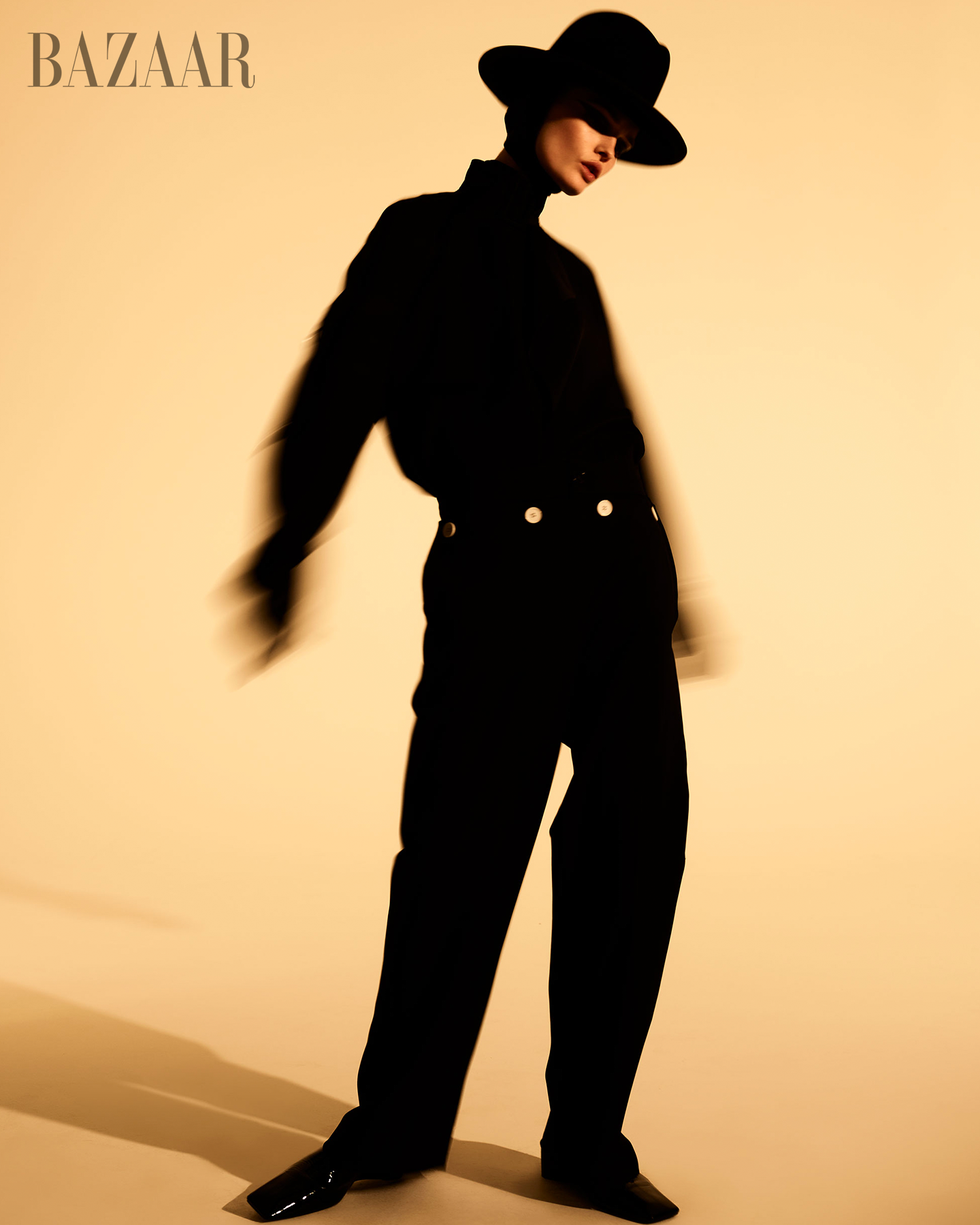 fashionable silhouette wearing a black outfit and hat