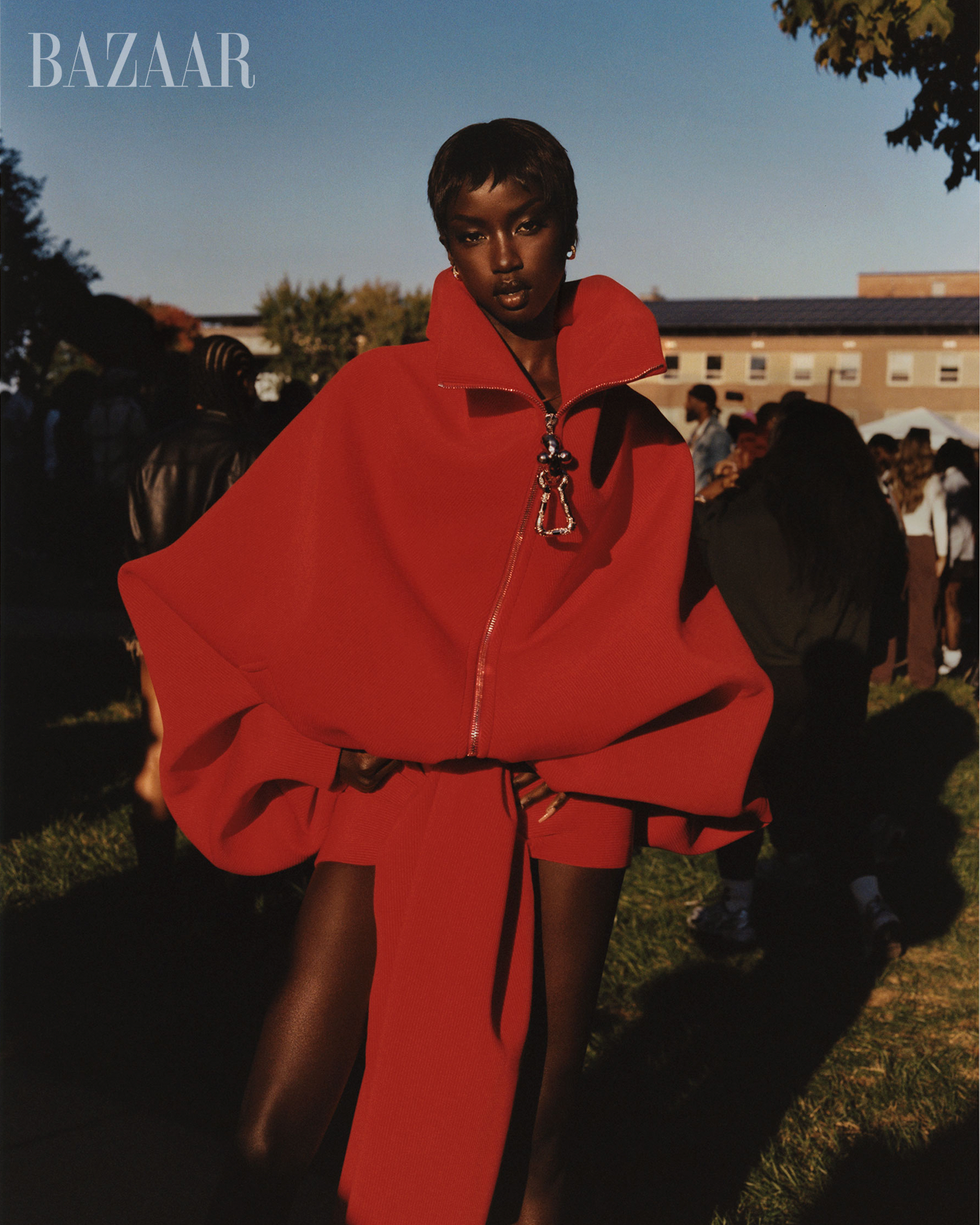 a model showcasing a striking red outerwear piece in a lively outdoor setting