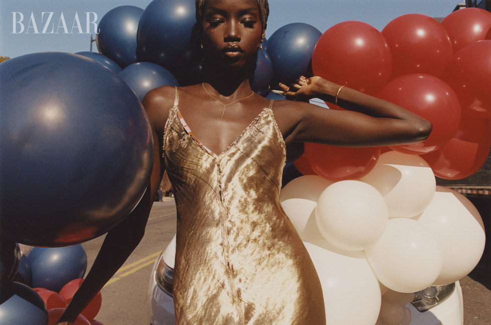 fashion shoot featuring a model in a golden dress amidst colorful balloons