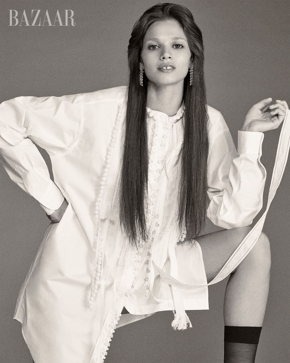 a fashion model wearing a white oversized shirt with long hair styled straight