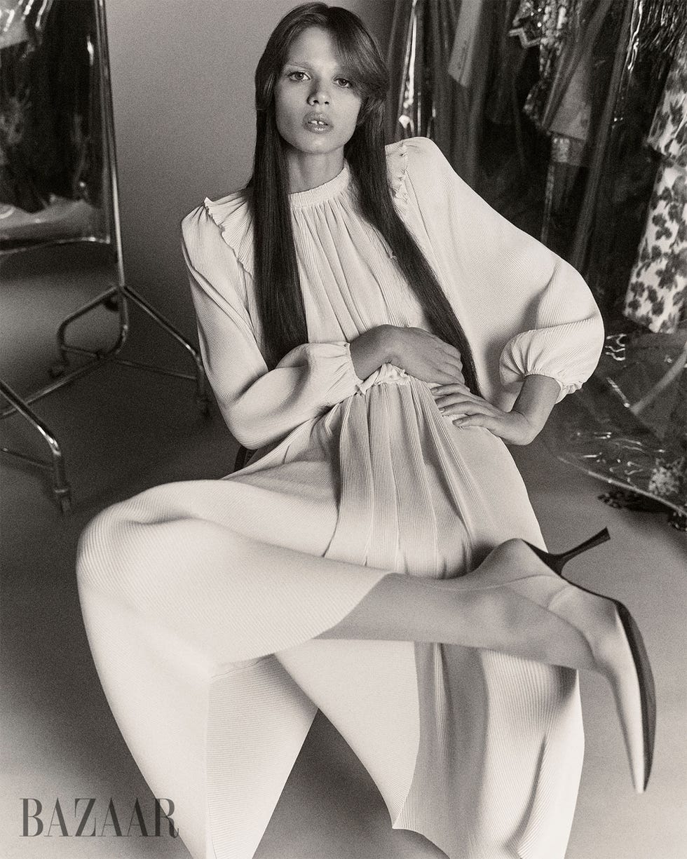 fashion model posing in a stylish flowing white dress with high heels