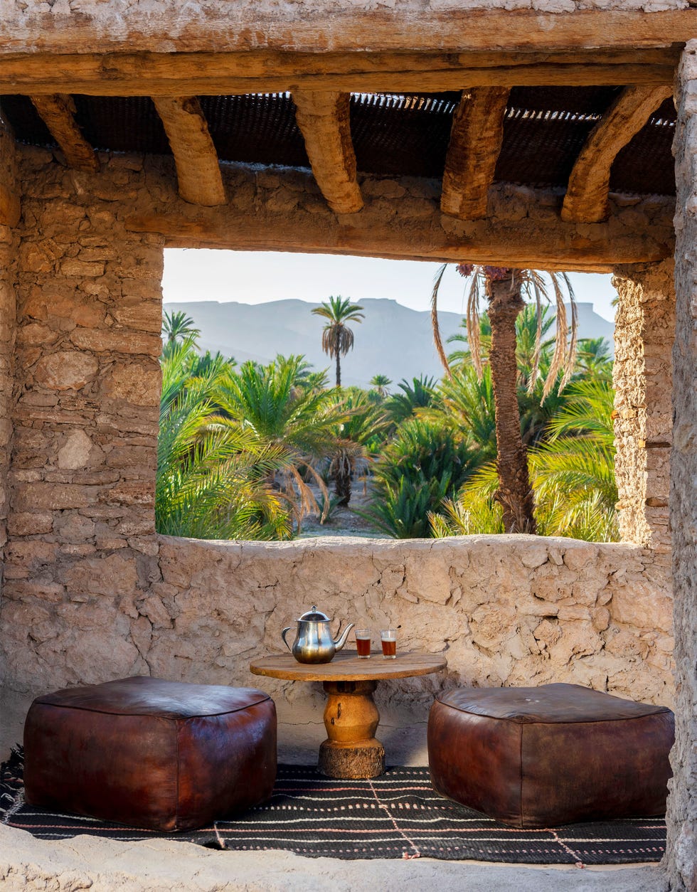 rustic seating area with a view of palm trees and mountains