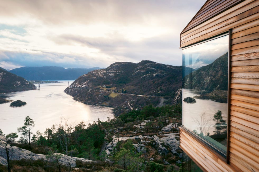 Scenic view from a modern wooden structure overlooking a fjord and mountains