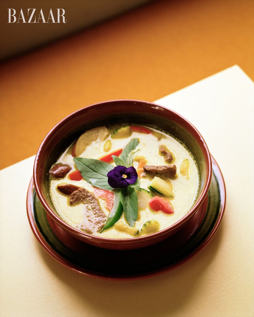 bowl of soup with purple flower garnish closeup portrait shot