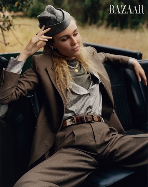 woman in brown suit and gray hat sitting on black leather car seat