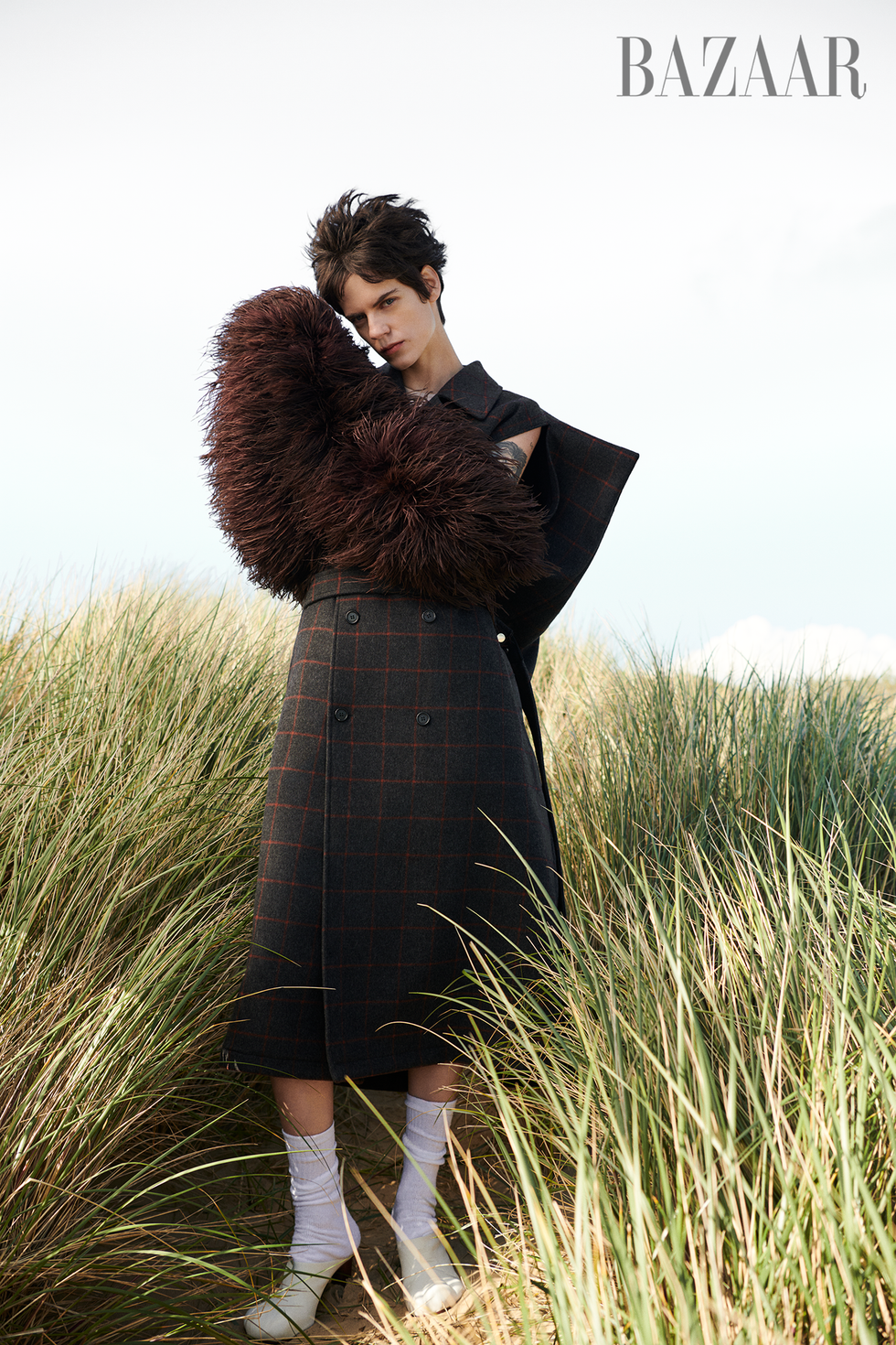 trench coat\, feather stole from the michael clark archive\, socks\, and mules\, jw anderson home county plaids, patterns, and textured knits