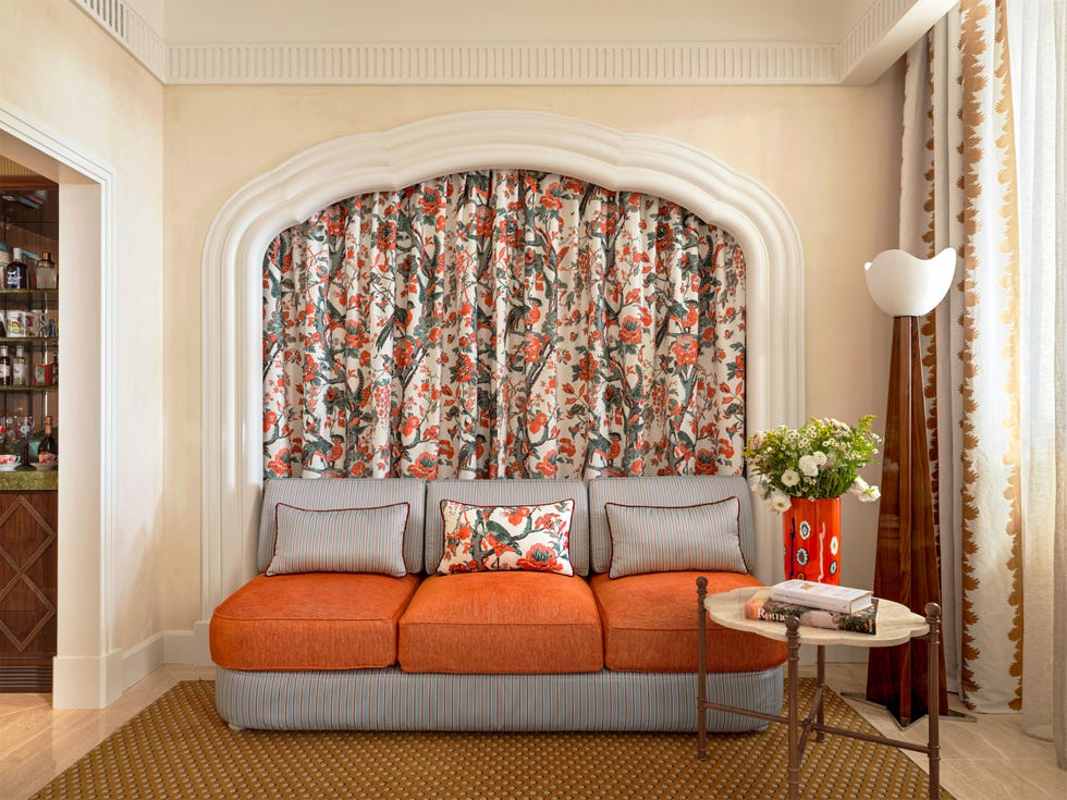 Brightly decorated seating area featuring floral curtains and a stylish lamp