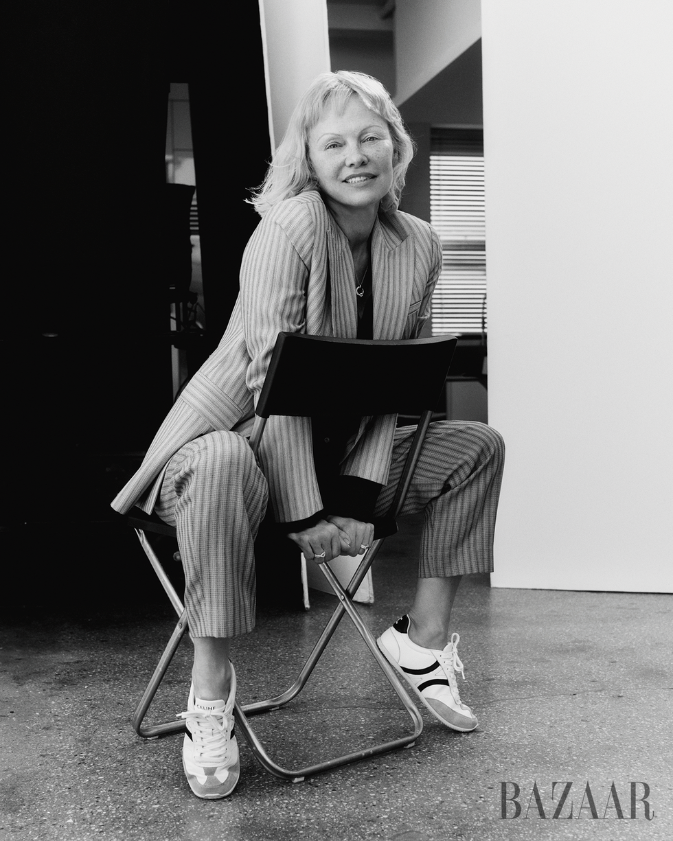 seated person in a striped suit and sneakers on a folding chair