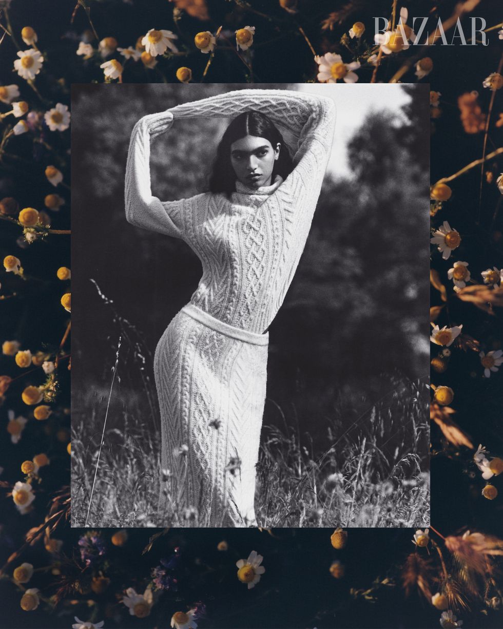 black and white image of woman in matching sweater and skirt in field