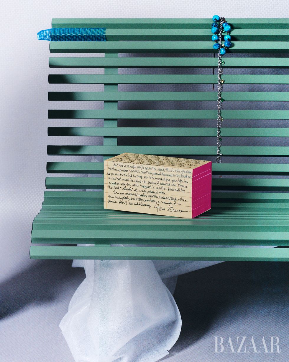 close up of box on a green bench with blue jewelry on the bench