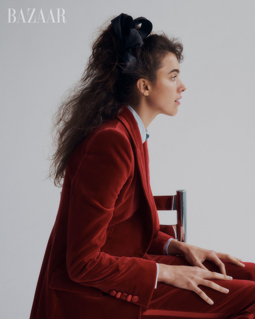 woman in red suit facing sideways on silver chair