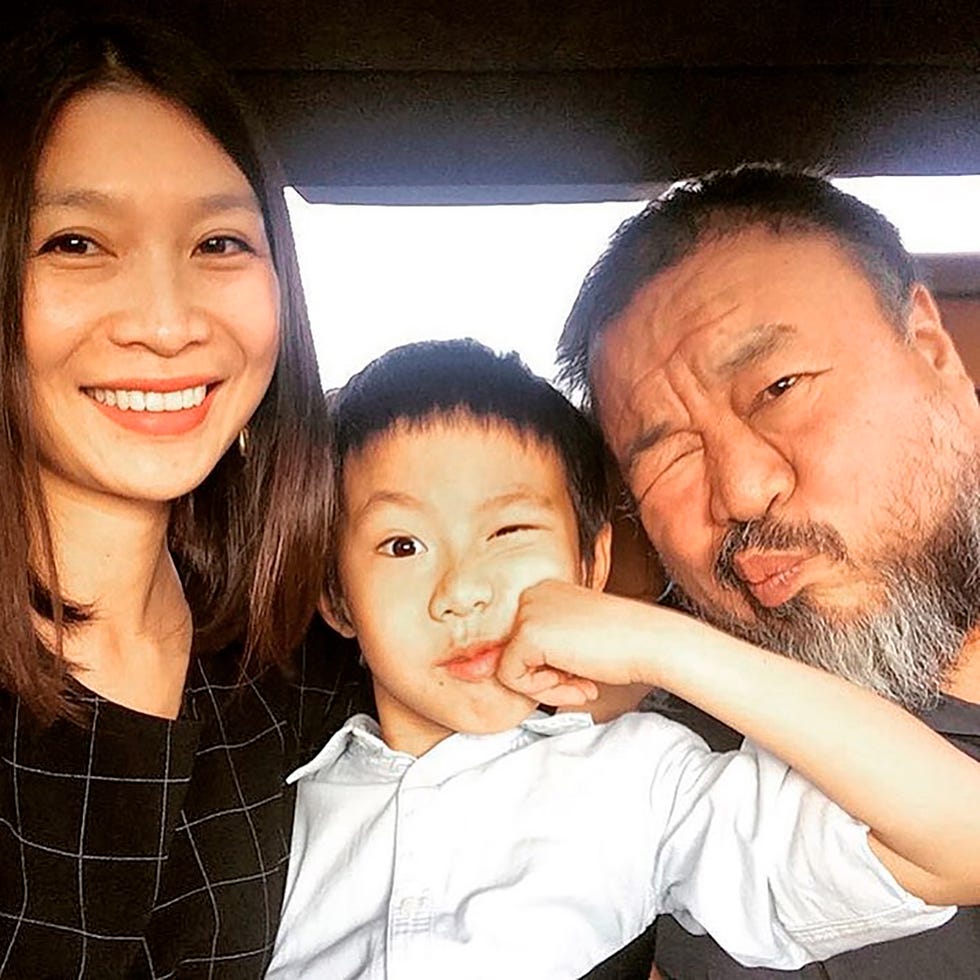 a selfie of chinese artist ai wei wei making silly faces with his son and smiling partner