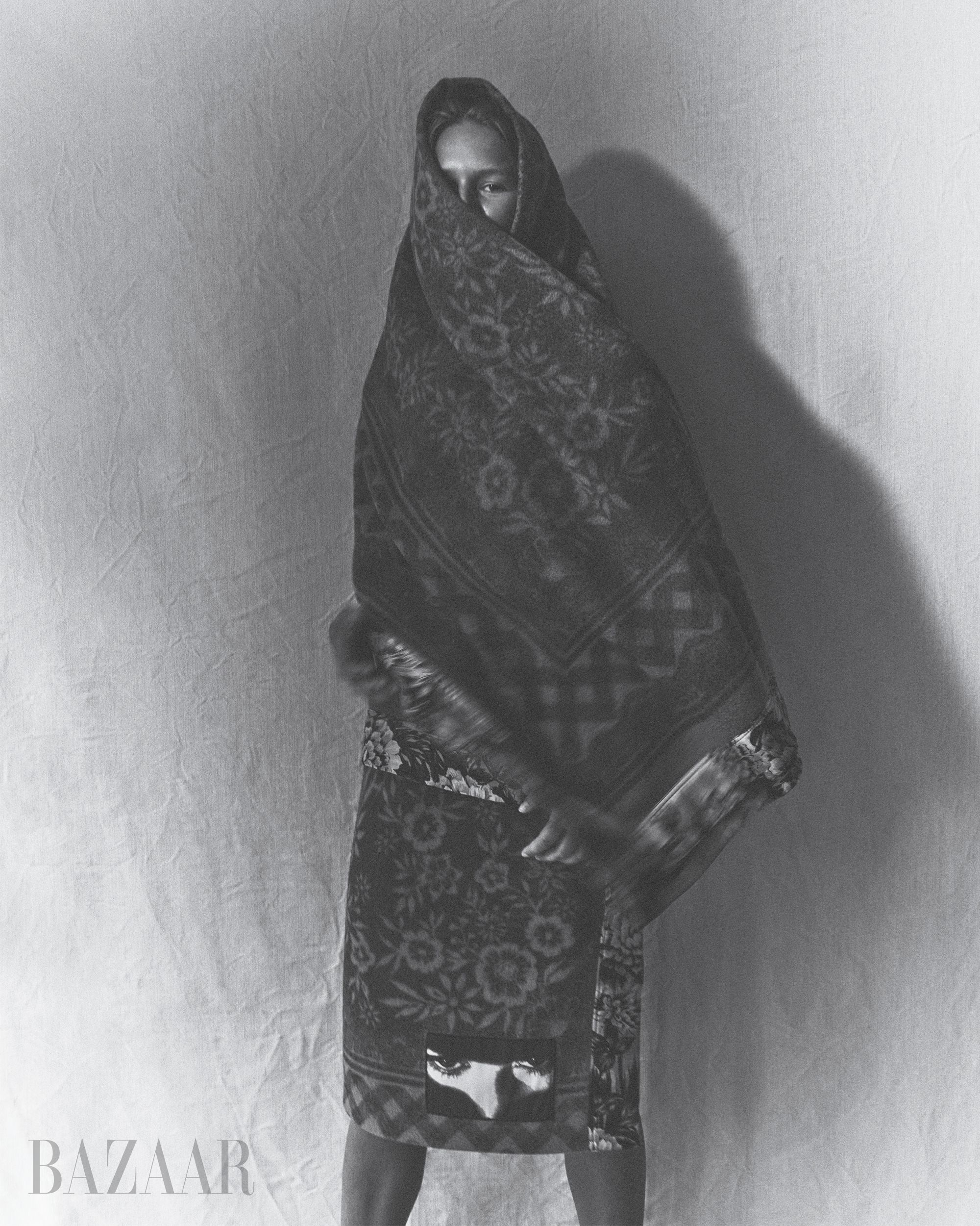 blackwhite image of model anna ewers in floral patterned blanket and skirt