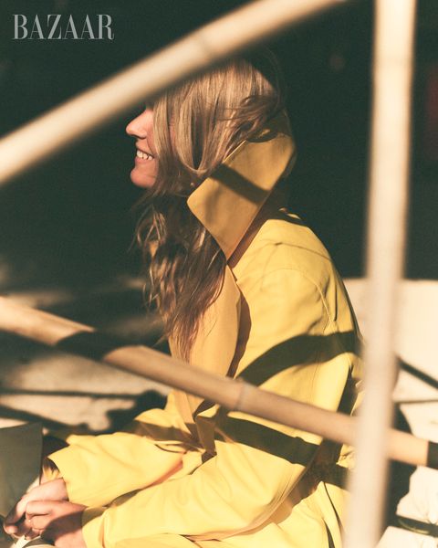 model anna ewers in yellow coat looking to camera left and smiling