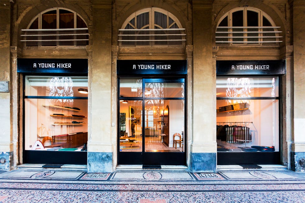 storefront of a retail shop named a young hiker with large windows displaying interior merchandise