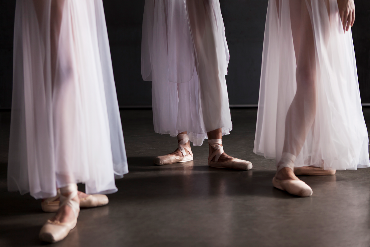 three ballerinas legs standing next to each other waiting for instruction