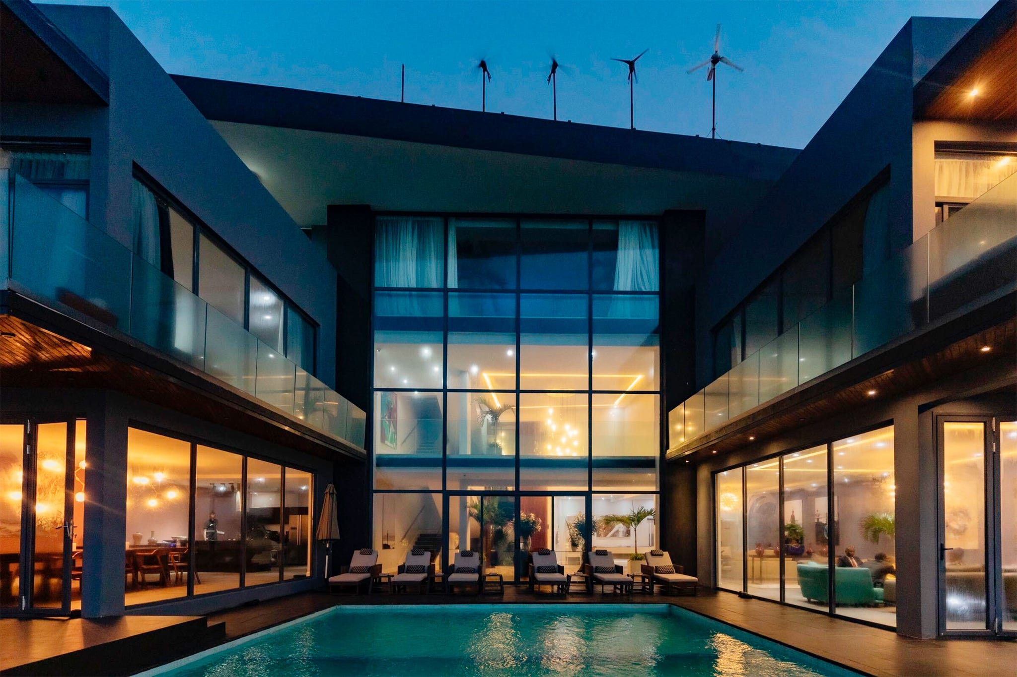 modern villa with a swimming pool and glass walls at dusk