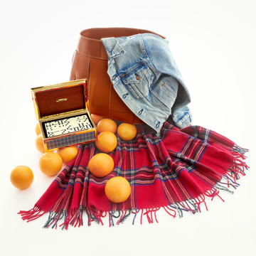 A stylish flat lay featuring a brown bag a denim jacket a vibrant red plaid scarf scattered oranges and a decorative box A stylish flat lay featuring a brown bag a denim jacket a vibrant red plaid scarf scattered oranges and a decorative box