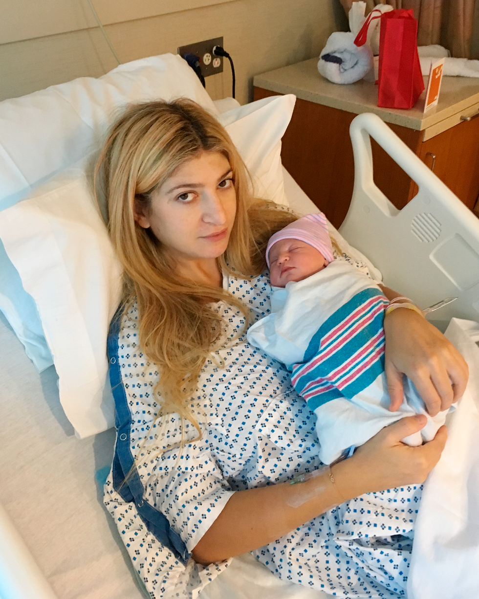 a woman holding a newborn baby in a hospital setting