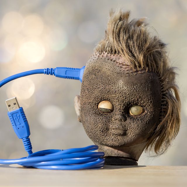 head of a doll with a cable of computer connected to the brain