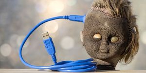 head of a doll with a cable of computer connected to the brain