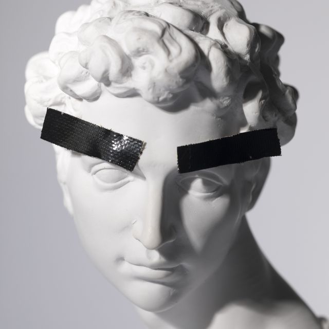 head sculpture with tape over eyebrows