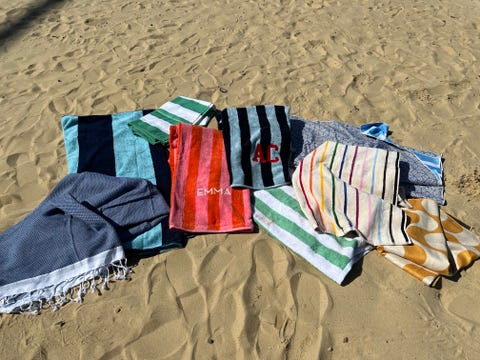 a bunch of beach towels laid out in the sand, good housekeeping's best beach towels