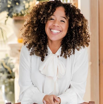 woman sitting at a table wearing a white blouse with a bow tie woman sitting at a table wearing a white blouse with a bow tie