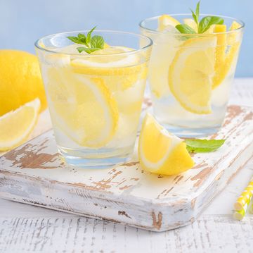 Cold refreshing summer drink with lemon and mint on wooden background.