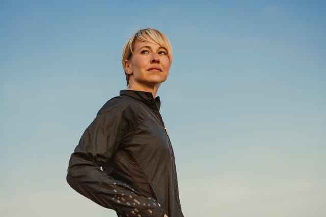 athlete in a sporty outfit posing outdoors against a clear sky