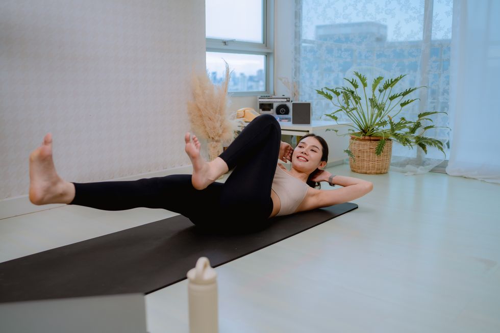 healthy asian woman exercising yoga at home