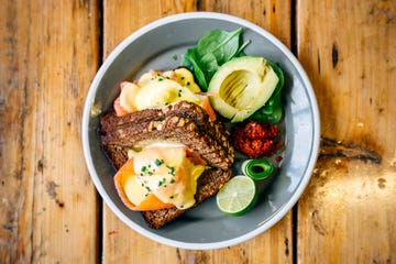 healthy breakfast with rye bread, salmon, poached egg, avocado and lime