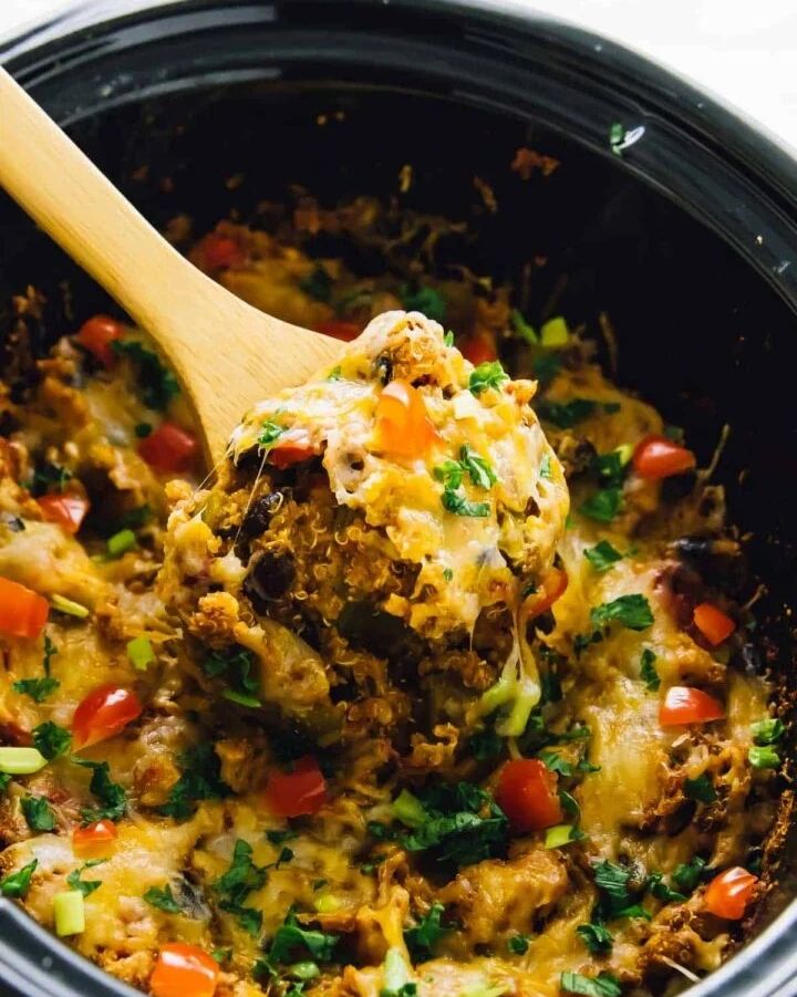 slow cooker quinoa enchilada casserole with wooden spoon