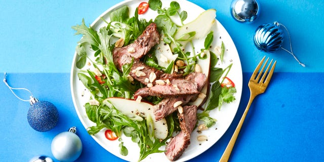 steak and pear salad on a white plate