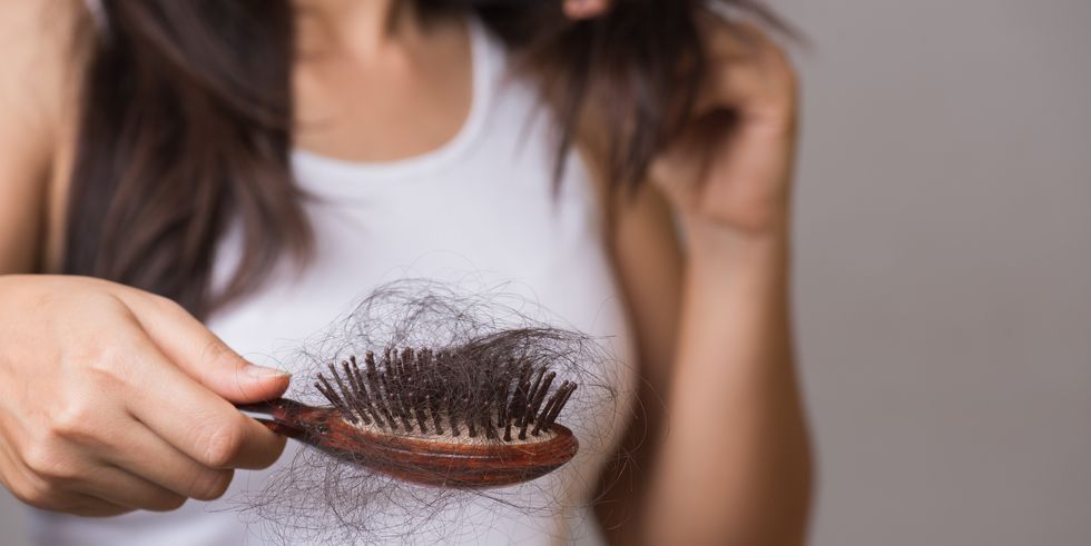 healthy concept woman show her brush with long loss hair and looking at her hair