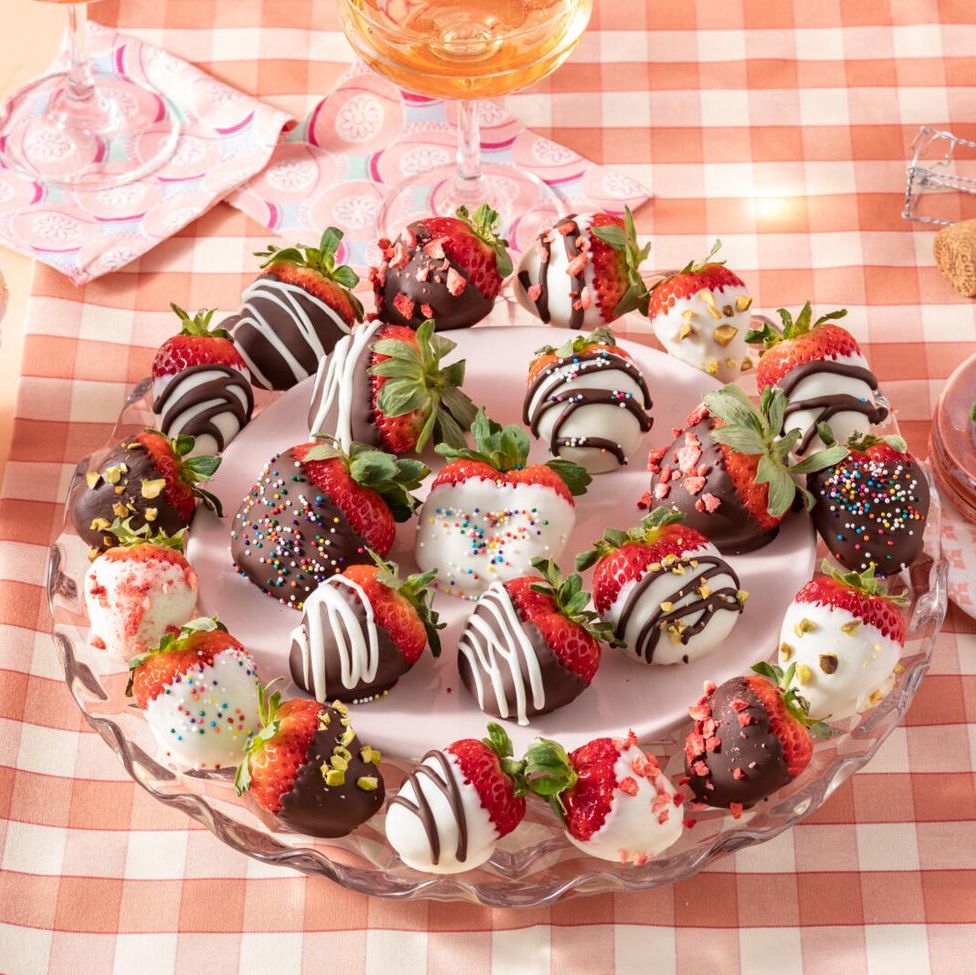 chocolate covered strawberries with different toppings on round plate