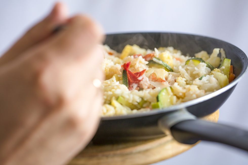Healthy eating - rice with vegetables on frying pan